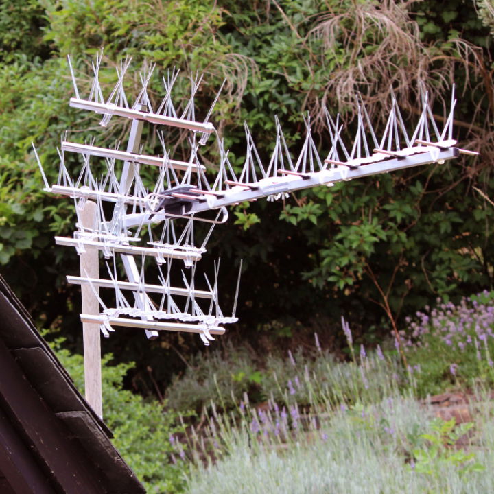 Defender® TV Aerial Spikes installed on a large TV aerial on a slated grey roof 