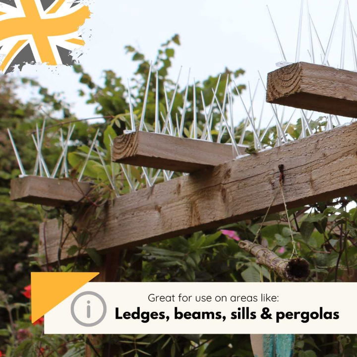 Defender wide plastic bird spikes installed on wooden beams of a pergola, surrounded by greenery, preventing birds from perching or nesting.